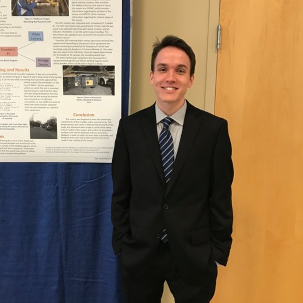 Matthew Finley standing next to a research poster