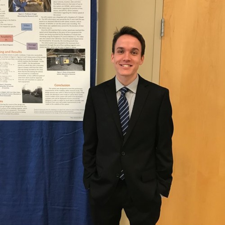 Matthew Finley standing next to a research poster