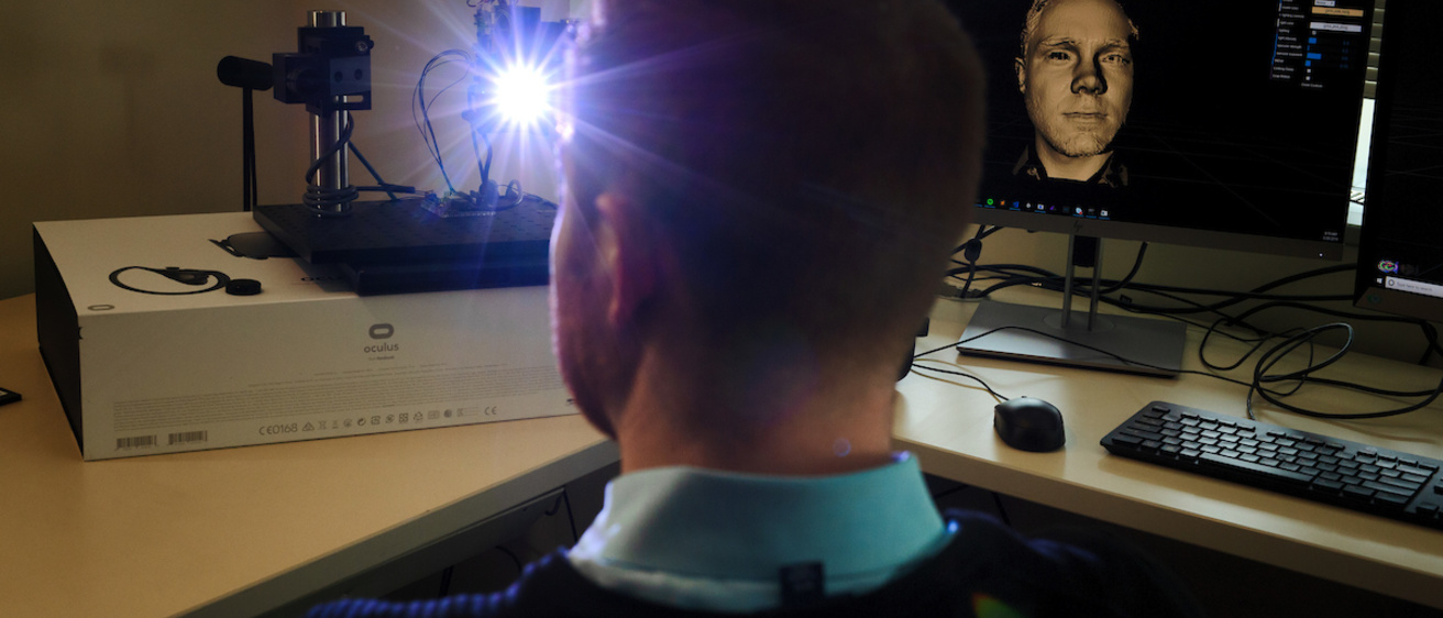 Photo of Tyler Bell looking into a camera at his desk