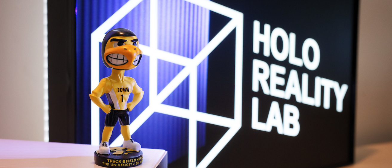 A Herky figure standing in front of a Holo Reality Lab sign