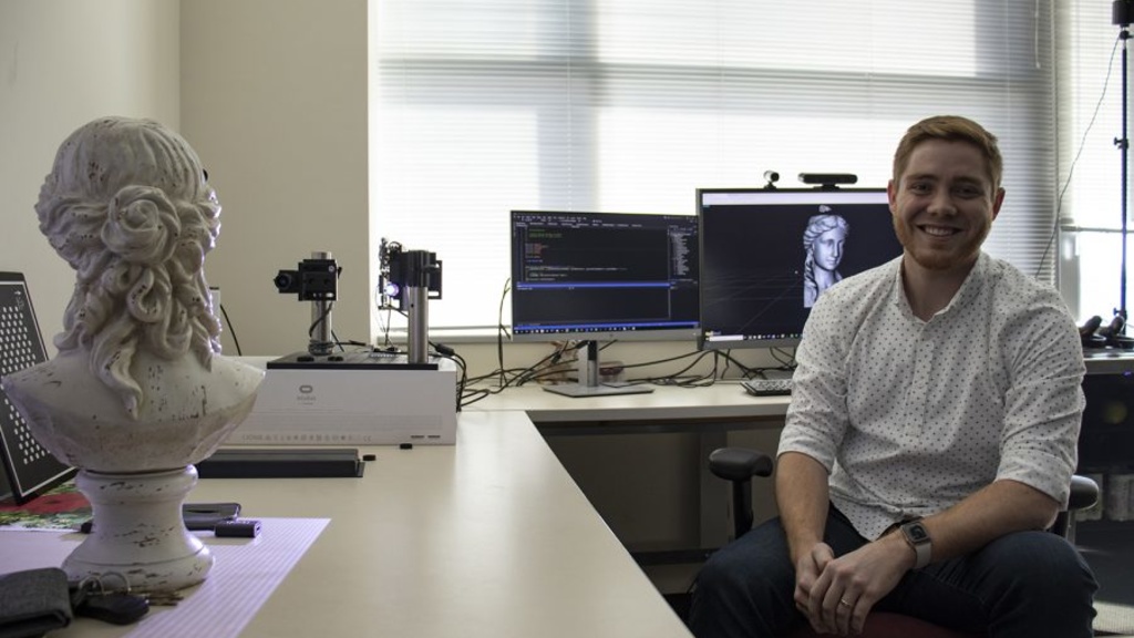 Tyler Bell poses for a portrait in his office