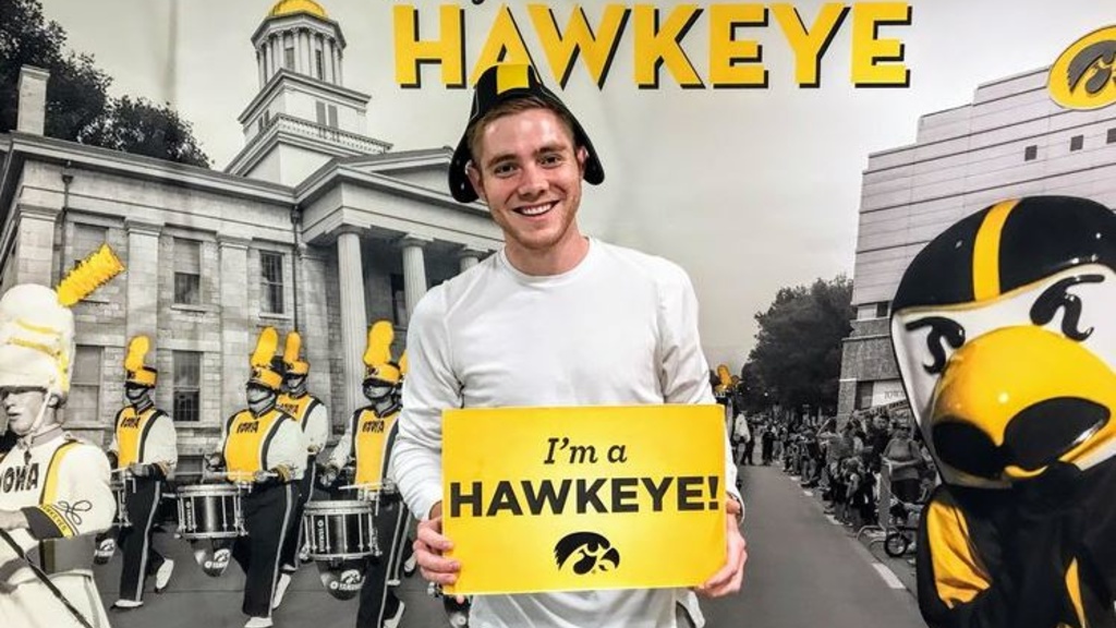 Tyler Bell holding an "I'm a Hawkeye!" sign
